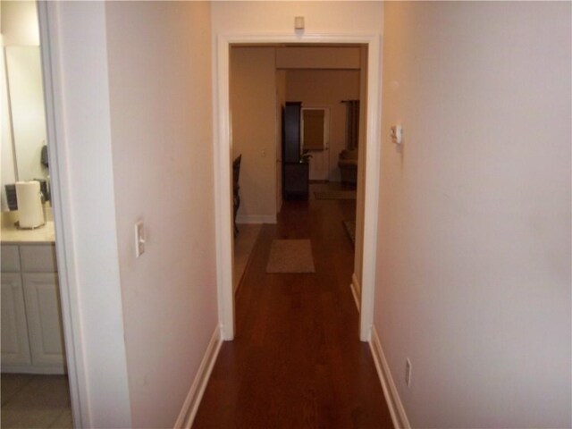 hallway with wood finished floors and baseboards