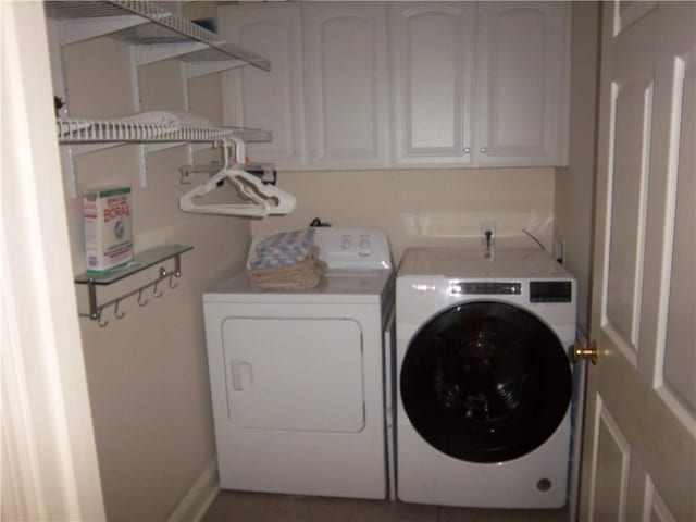 laundry room featuring independent washer and dryer and cabinet space