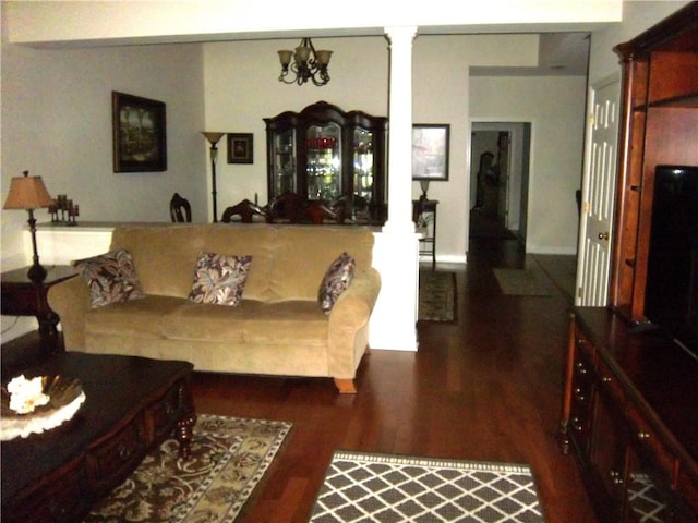 living area featuring ornate columns and wood finished floors
