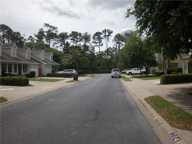 view of asphalt road with curbs and sidewalks