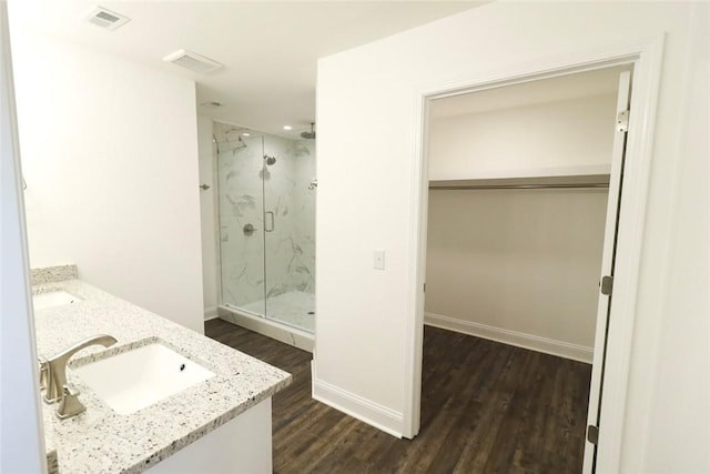 bathroom with vanity, a shower with shower door, and hardwood / wood-style flooring