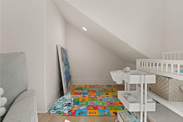 playroom featuring baseboards, lofted ceiling, and wood finished floors