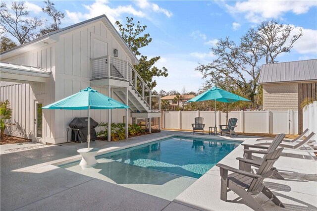 view of pool with a patio area, stairway, area for grilling, and fence