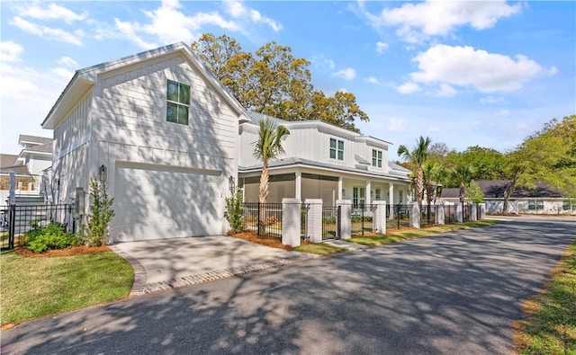 view of front of home with a fenced front yard, a garage, and driveway