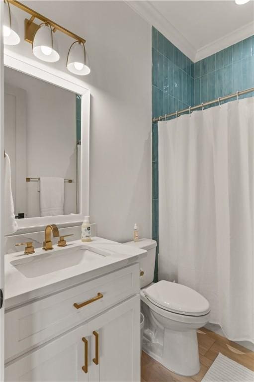 bathroom featuring vanity, toilet, a shower with curtain, and ornamental molding