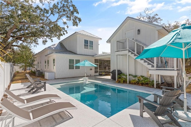 back of property featuring a standing seam roof, stairway, board and batten siding, and a patio