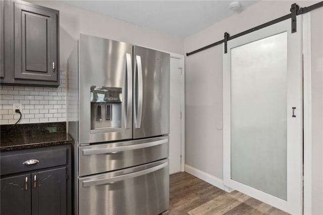 192 W Maple Ave, Kingsland, GA 31548 - kitchen featuring stainless steel fridge, a barn door, decorative backsplash, and wood finished floors