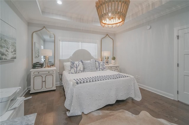 bedroom with a tray ceiling, dark hardwood / wood-style flooring, ornamental molding, and a notable chandelier