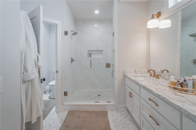 bathroom with vanity, a shower with shower door, and toilet