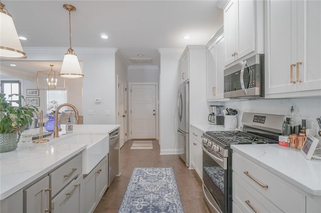 kitchen with white cabinetry, sink, stainless steel appliances, decorative light fixtures, and ornamental molding