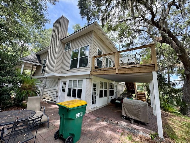1356 Fiddler Trce NE, Townsend, GA 31331 - back of property with a patio area, stairs, a chimney, and a deck