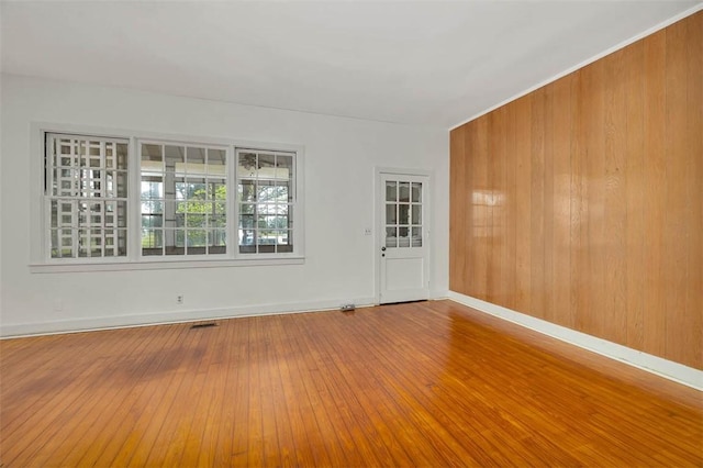 spare room with wood-type flooring and baseboards