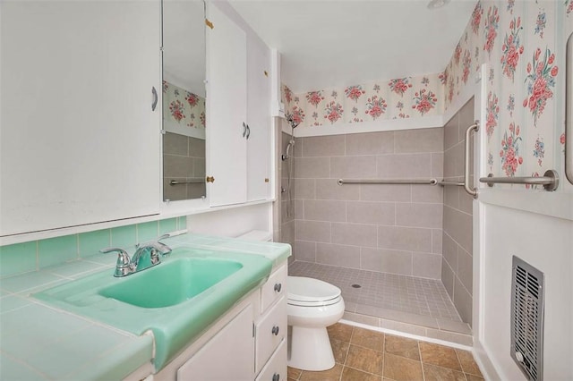 full bath featuring toilet, a stall shower, vanity, and wallpapered walls