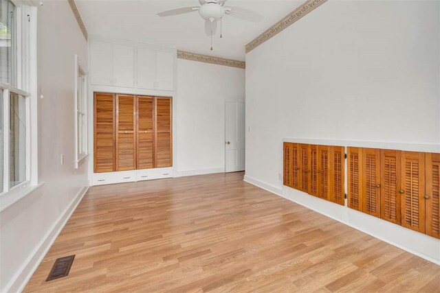 spare room with ceiling fan, light wood-style flooring, and baseboards