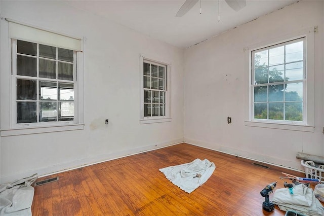 unfurnished room featuring a ceiling fan, baseboards, and wood finished floors