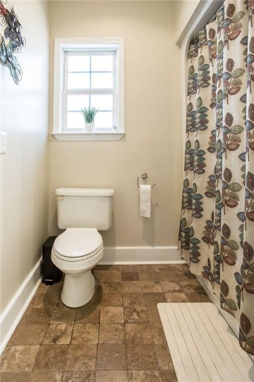 bathroom with a shower with curtain and toilet