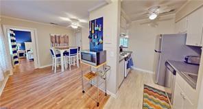 800 Mallery St Unit 3, Saint Simons Island, GA 31522 - kitchen with stainless steel microwave, ornamental molding, light wood-style floors, baseboards, and ceiling fan