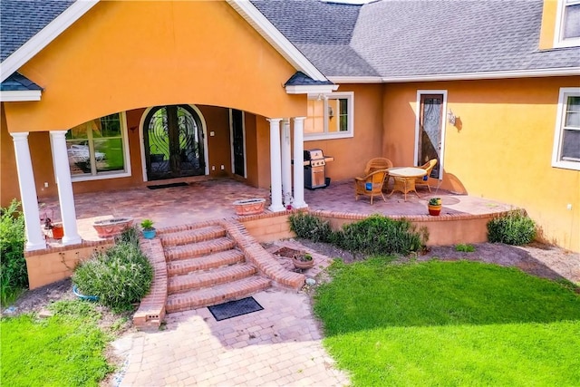 4949 Trudie Rd, Blackshear, GA 31516 - property entrance featuring roof with shingles, stucco siding, and a patio