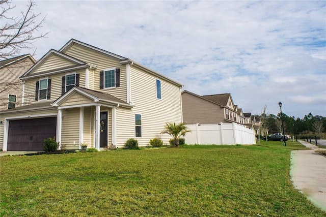 view of front of home with a garage, concrete driveway, a front lawn, and fence