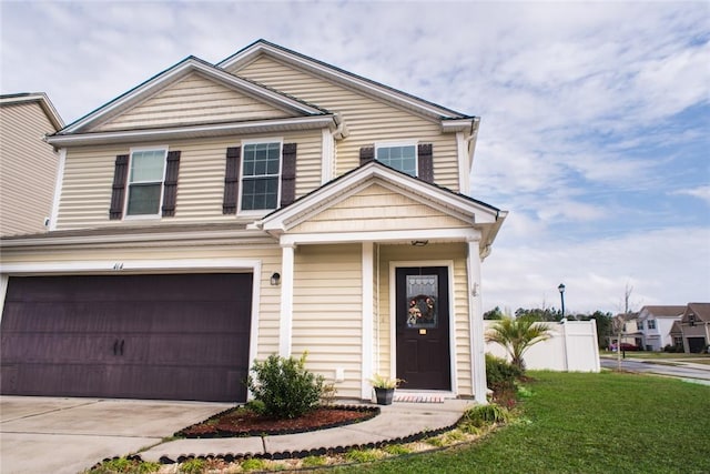 view of front of property featuring a front lawn, concrete driveway, and an attached garage