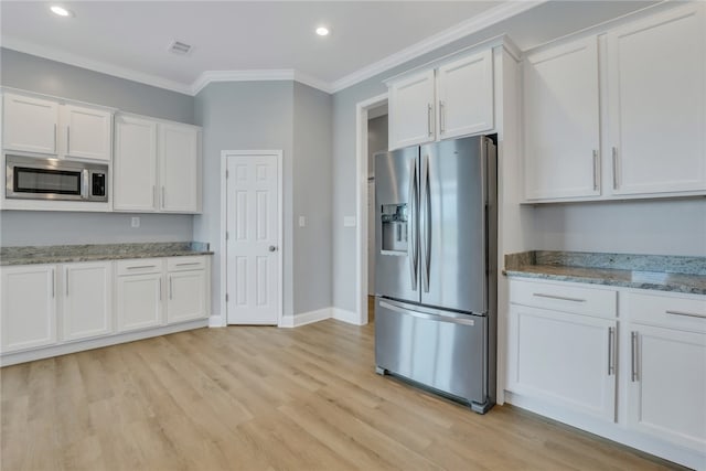 kitchen with white cabinets, light hardwood / wood-style floors, light stone counters, and appliances with stainless steel finishes