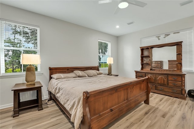 bedroom with multiple windows, ceiling fan, and light wood-type flooring