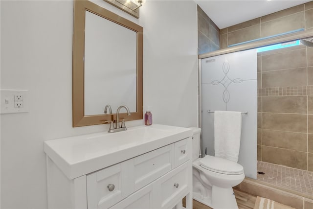 bathroom with an enclosed shower, vanity, and toilet