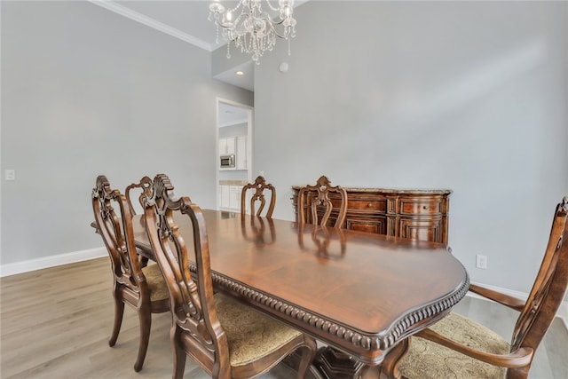 dining area featuring a chandelier, light hardwood / wood-style floors, and crown molding