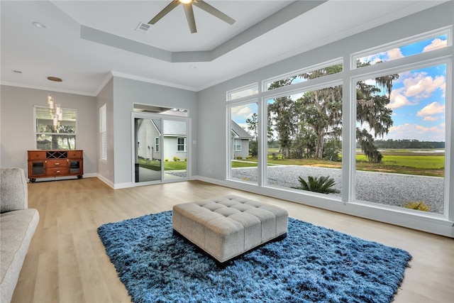 sitting room featuring hardwood / wood-style floors, ceiling fan, ornamental molding, and a wealth of natural light