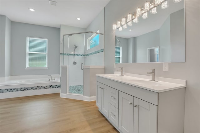 bathroom with vanity, wood-type flooring, and independent shower and bath