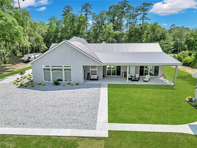 back of property featuring outdoor lounge area, a patio area, and a lawn