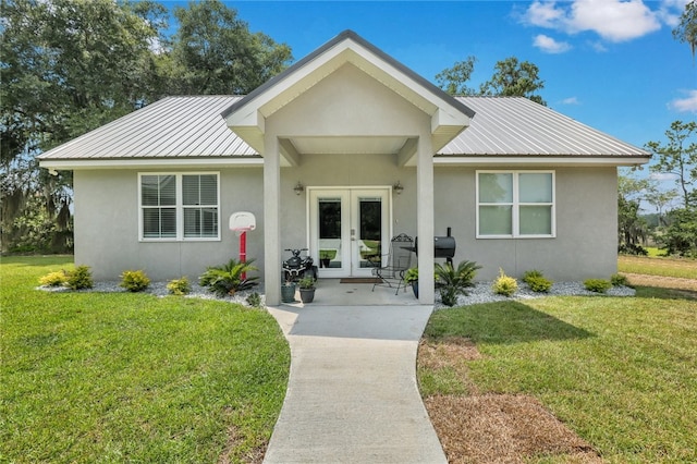 view of front of house featuring a front yard and french doors