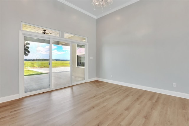 spare room with ceiling fan with notable chandelier, ornamental molding, and light hardwood / wood-style flooring