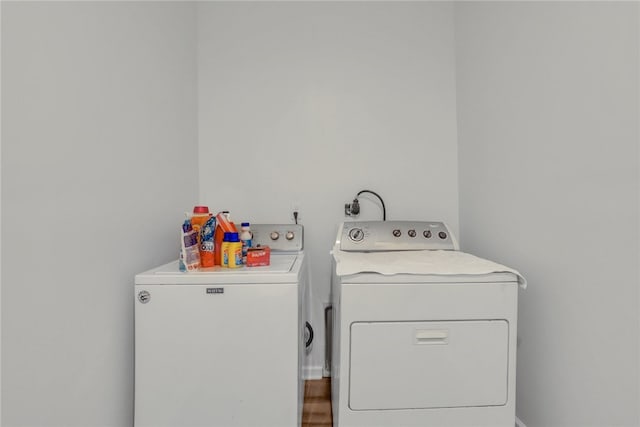 washroom with independent washer and dryer and wood-type flooring