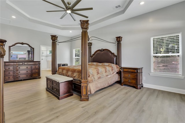 bedroom with light wood-type flooring, ensuite bath, multiple windows, and ceiling fan