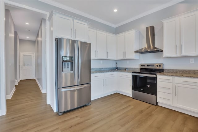 kitchen featuring white cabinets, wall chimney exhaust hood, appliances with stainless steel finishes, and light hardwood / wood-style flooring