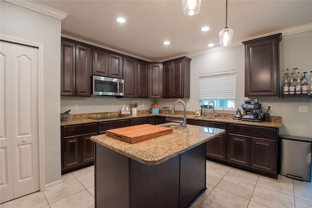 200 Pistachio Ln, Kingsland, GA 31548 - kitchen featuring stainless steel microwave, light tile patterned floors, ornamental molding, light stone counters, and dark brown cabinetry