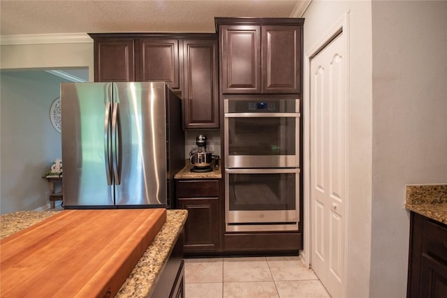 200 Pistachio Ln, Kingsland, GA 31548 - kitchen featuring stainless steel appliances, dark brown cabinetry, crown molding, and light stone counters