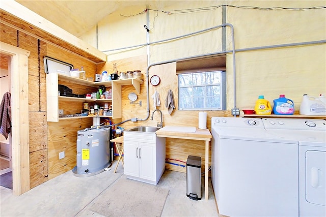 clothes washing area featuring water heater, sink, cabinets, and washer and clothes dryer