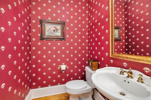126 Riverwalk Dr, Brunswick, GA 31523 - half bath with a sink, wood finished floors, wallpapered walls, baseboards, and toilet