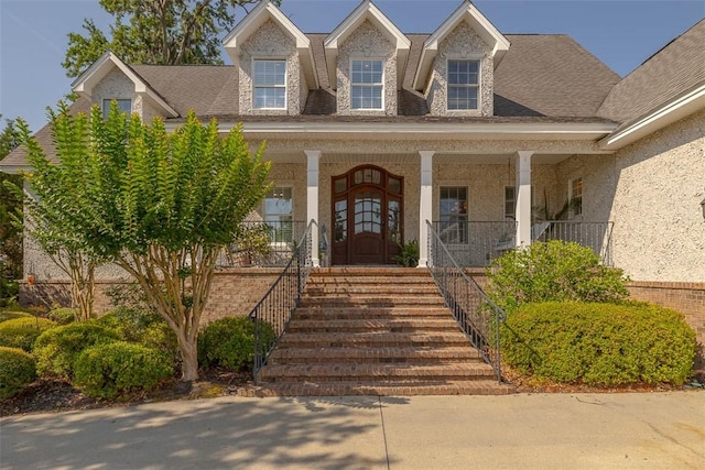 126 Riverwalk Dr, Brunswick, GA 31523 - view of front facade with a porch, stucco siding, and a shingled roof