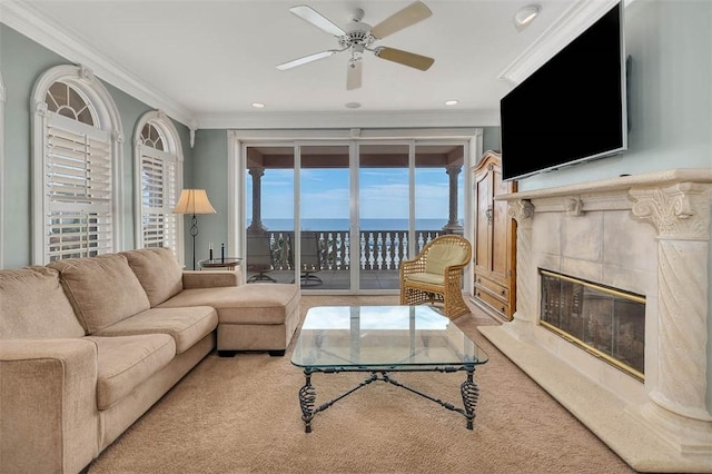 living room featuring a tiled fireplace, crown molding, and ceiling fan