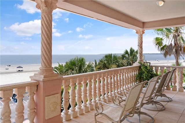 balcony featuring a water view and a beach view