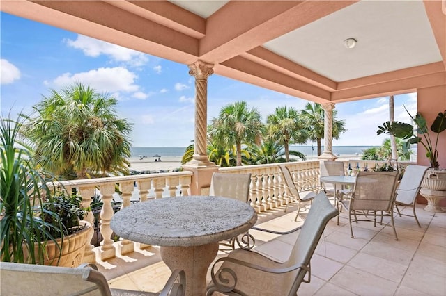 view of patio with a water view and a beach view