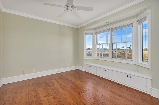 spare room featuring hardwood / wood-style floors, crown molding, and ceiling fan