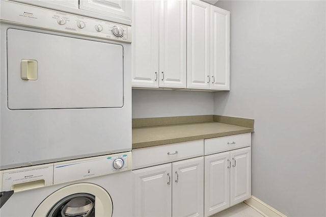 laundry room featuring stacked washer / dryer and cabinets