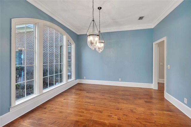 empty room with hardwood / wood-style flooring, ornamental molding, and a wealth of natural light