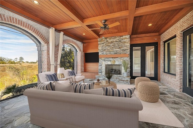 view of patio / terrace featuring ceiling fan, french doors, and an outdoor stone fireplace