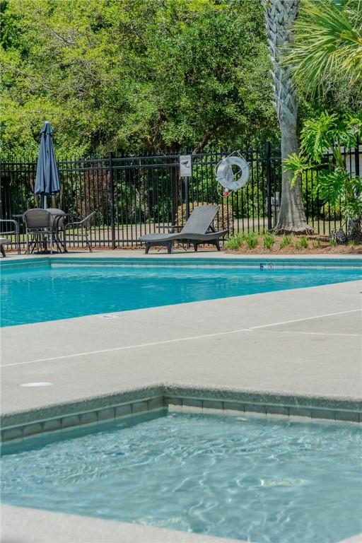 pool with fence and a patio
