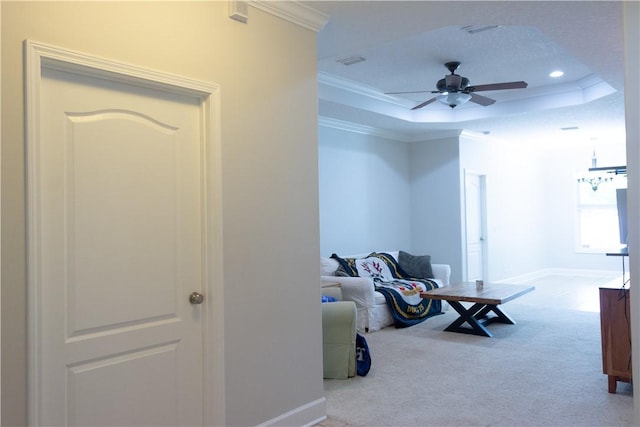 interior space with crown molding, baseboards, carpet floors, and a raised ceiling